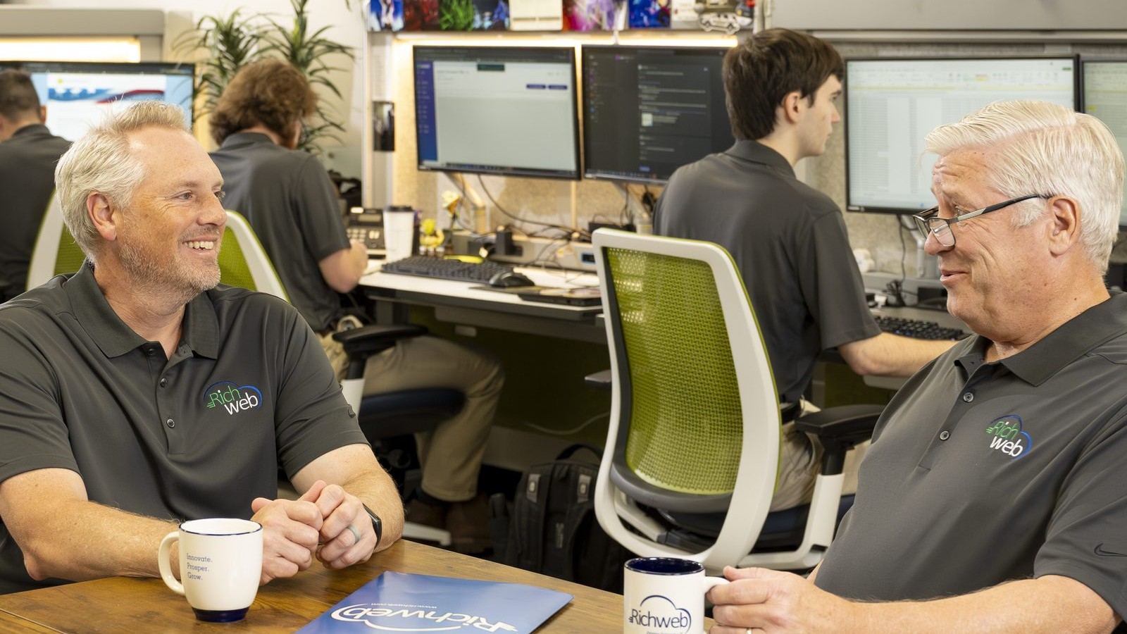 Two Richweb staff talking through a partner plan at the office